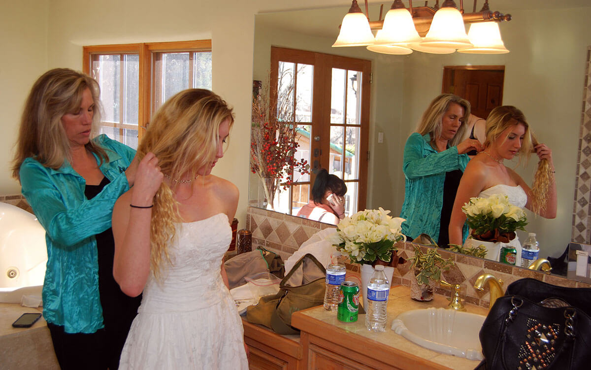 mother helping daughter get ready for her wedding